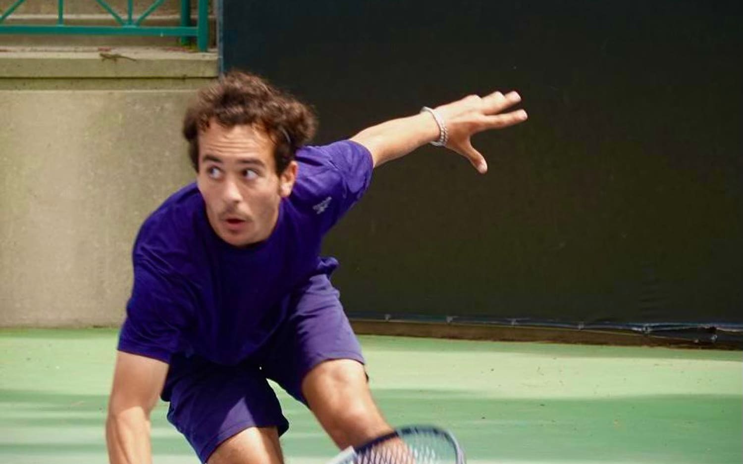 Stretching for a low volley in live-ball practice — high-level hitting partner in Los Angeles