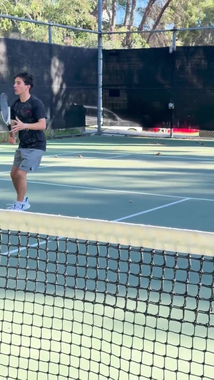 Tennis player in ready position preparing to split step during a training session